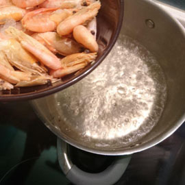 les crevettes congelées sont jetées dans de l'eau bouillie